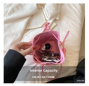 Internal view of a pink woven bucket bag showing space for a phone and sunglasses