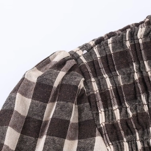 Macro shot of brown honeycomb lattice fabric and pleated shoulder seam on the blouse