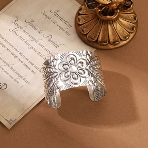 Detailed macro view of vintage silver floral embossed wide open cuff bangle with texture