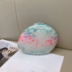 Detail of egg-shaped marble evening clutch featuring pink-blue gradient resin texture