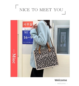 Leopard print tote bag with brown handles and long shoulder strap for daily commuting