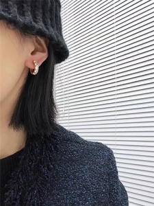 Close-up of elegant gold plated hoop earring with white zircons on female model