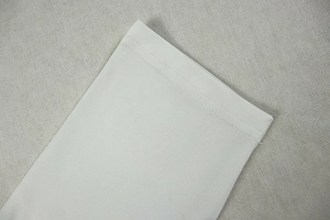 Detailed view of precise white stitching and dense plain weave fabric on a dress