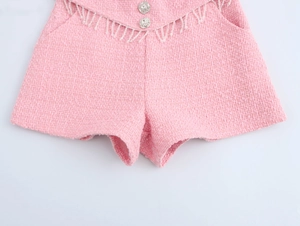 Detail der rosa Tweed-Shorts mit glitzernden Strassknöpfen und elegantem Fransenbesatz