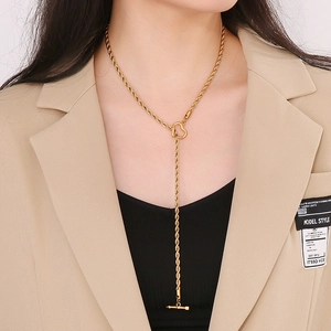 Dettaglio della chiusura a cuore e freccia dorata su una collana chic a maglia serpente