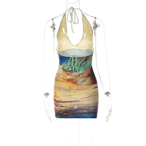 Detail of summer knit halter dress featuring yellow crochet bodice and blue abstract print skirt