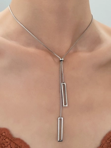 Detail of silver adjustable Y-necklace with geometric rectangle charms on a model