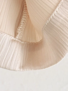 Vue détaillée du tissu en maille côtelée beige et des coutures soignées d'un blazer