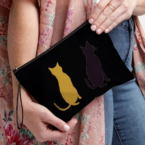 Black cosmetic bag with cute cat silhouette print held by a model for daily lifestyle use