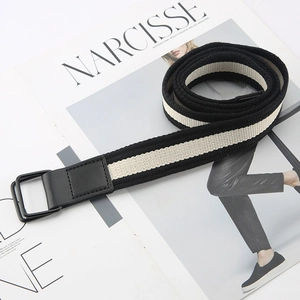 Striped canvas belt with double D-ring metal buckle on a minimalist fashion magazine