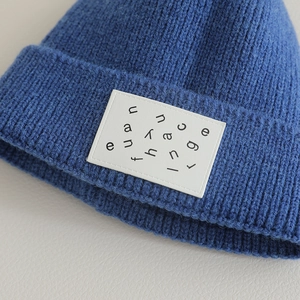 Blue ribbed knit beanie for kids featuring a stylish lettered patch on the folded brim