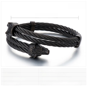 Macro shot of double-braided steel rope bracelet with detailed wolf head terminals