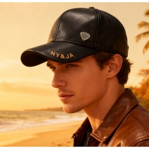 Close-up of black leather baseball cap with silver shield badge and embroidery