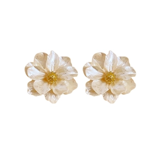 Elegant pearl-white resin flower earrings with gold center on a clean white background