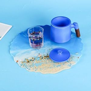 Detail of a handmade ocean-themed resin tray with real sand, shells and sea waves