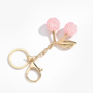 Porte-clés cerise avec strass roses et détails de feuilles en métal doré