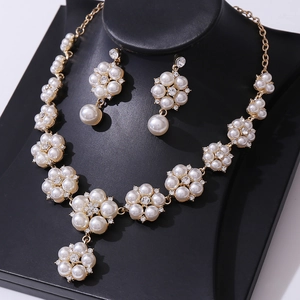 Elegant gold bridal jewelry set featuring white pearl floral necklace and stud earrings