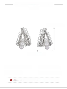 Detailed view of silver C-shaped earrings with pink zircon and pearl insets