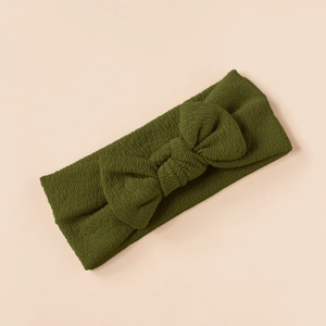 Olive green waffle knit baby headband featuring a large textured bow detail on beige background
