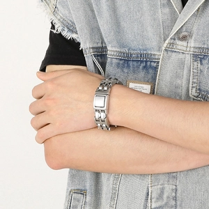 Close-up of industrial style silver steel chain bracelet worn by a male model