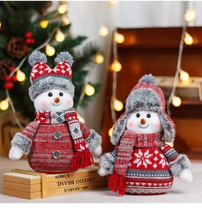 Détail de bonhommes de neige en peluche tricotée avec motifs de flocons pour Noël