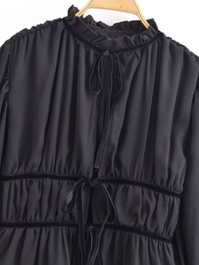Detail of ruffle neckline and black velvet ribbon ties on a French style blouse