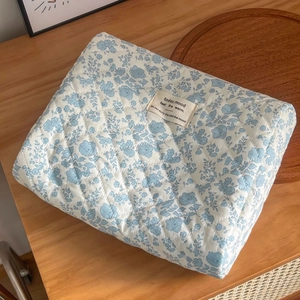 Quilted blue floral cosmetic bag with cotton fabric and embroidered woven label