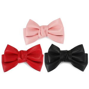 Detailed view of pink, red, and black PU leather bow hair clips on white background