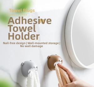 Detail of bear-shaped towel plugs mounted on marble wall with punch-free adhesive design