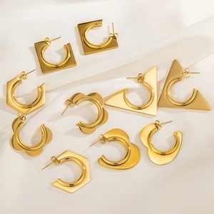 Macro shot of 18k gold plated stainless steel geometric earrings on white silk fabric