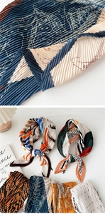 Close-up detail of pleated silk scarf with vintage map pattern and silky texture