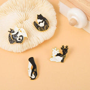 Détails de broches en émail noir et blanc avec animaux mystiques et motifs célestes
