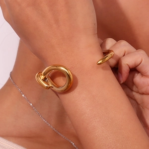 Detail of 18K gold plated stainless steel open bangle with twisted wire drop design