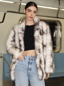 Detailed texture of mid-length faux fur coat with brown leopard spots in urban setting