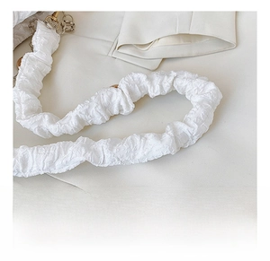 Detail of detachable pleated fabric shoulder strap with elegant metal chain hooks