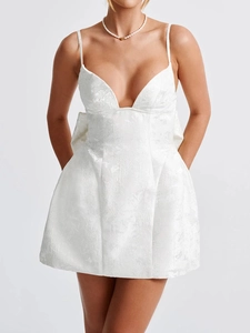 Macro shot of white jacquard fabric and back bow detail on a stylish mini party dress