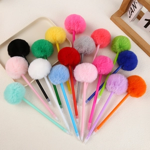 Creative colorful plush pom-pom ballpoint pens neatly arranged on a white textured desk