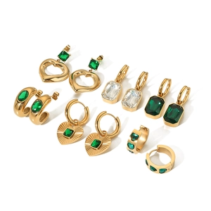 Set of gold-plated vintage earrings with emerald green heart zircons on white background