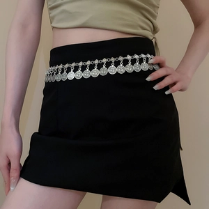 Detail view of silver metal waist chain featuring embossed coin pendants on black dress
