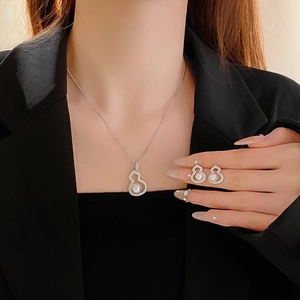 Detailed view of zircon gourd pearl necklace and earrings set worn by a model