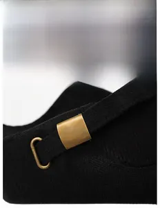 Close-up of adjustable bronze metal buckle and twill fabric texture on winter hat