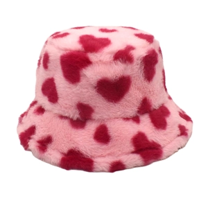 Close-up of pink faux fur bucket hat with red heart patterns and soft plush texture