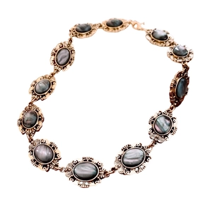 Vintage style gold necklace with oval grey resin stones and intricate carvings