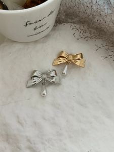 Détail de barrettes à double nœud dorées et argentées avec perles de goutte élégantes