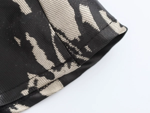 Close-up of black and beige jacquard woven fabric with detailed stitching and texture