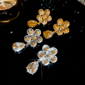 Macro shot of silver needle flower and waterdrop earrings with clear and champagne crystals