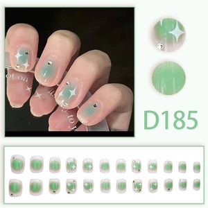 Green gradient press-on nails with white star patterns and small silver rhinestones