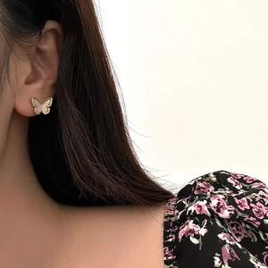Elegant gold butterfly stud earrings with white shell inlay and zircon accents on model