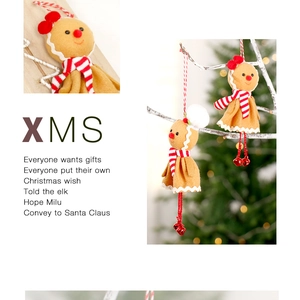 Detail of gingerbread man plush ornament with bell and scarf on a Christmas tree