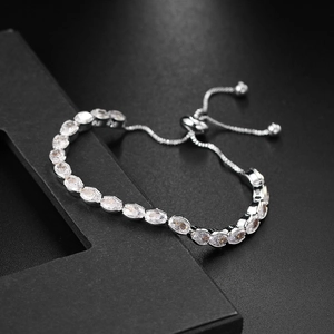 Macro detail of adjustable silver tennis bracelet featuring oval-cut cubic zirconia stones